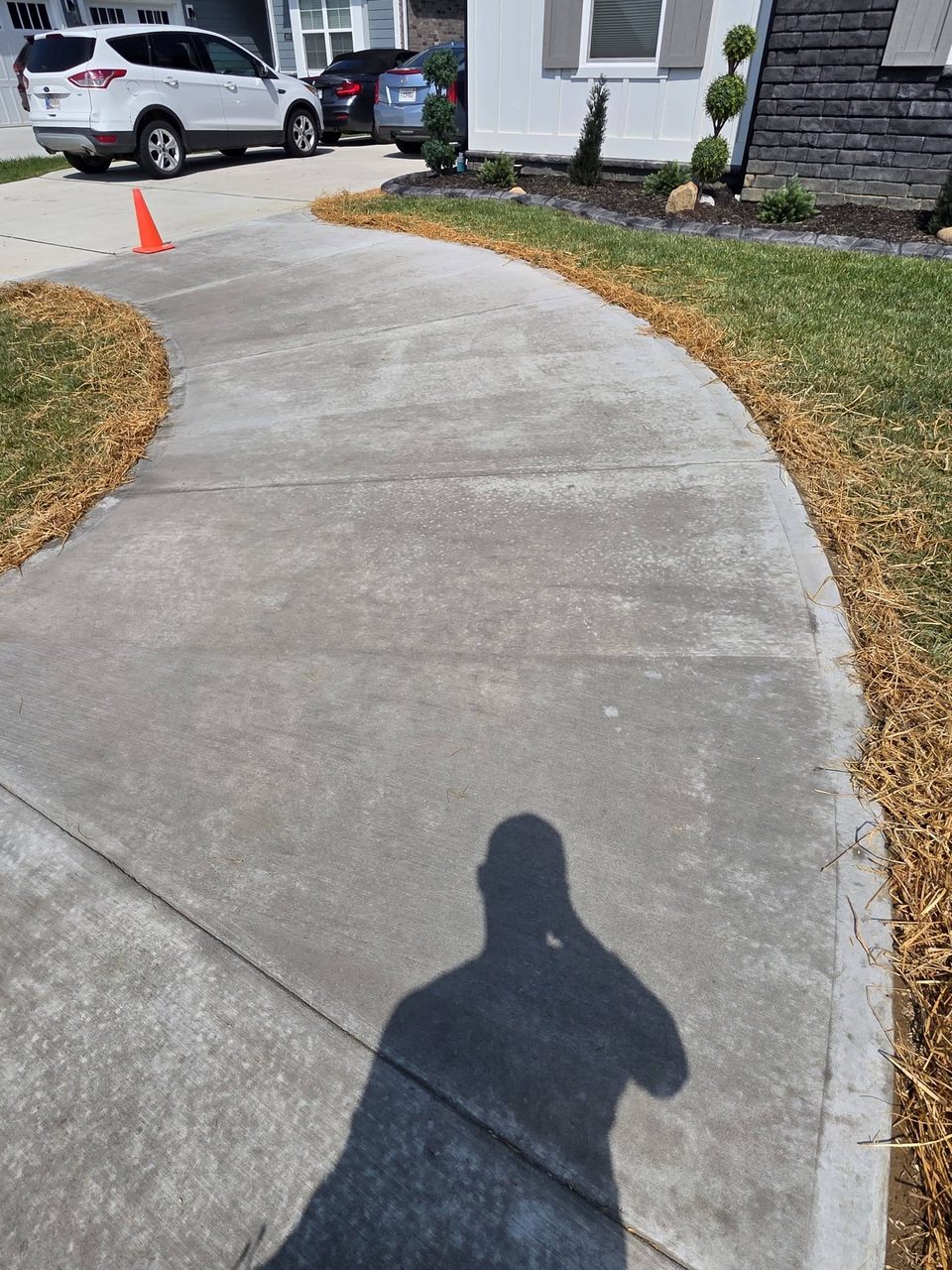 Finished concrete walkway with curved sweep tying into driveway, broom finish, Champions Point Henryville Indiana.